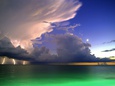 Lighting striking over green and blue water